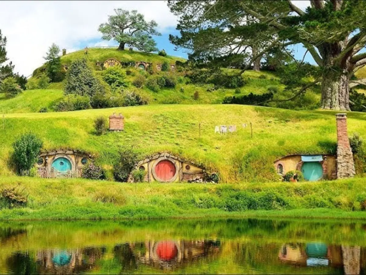 Hobbithus på en kulle vid en spegelsjö på Hobbiton movie Set. 