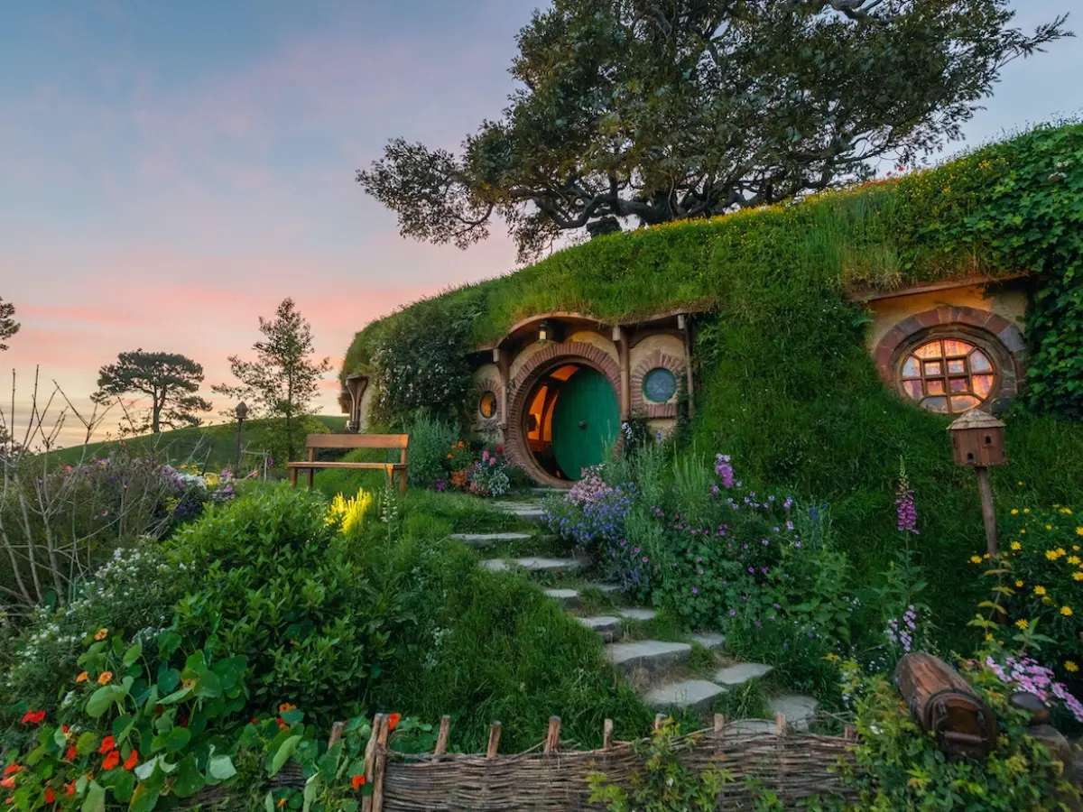 Hobbithus på en kulle i solnedgången, på hobbiton movie set i Nya Zeeland.